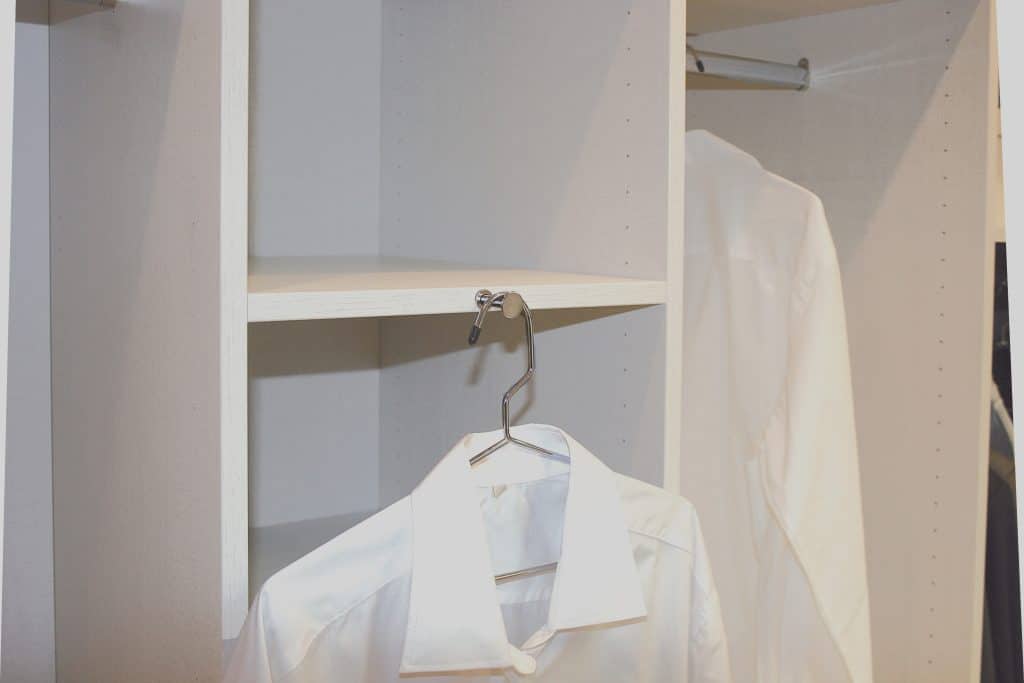 Une chemise blanche sur un cintre accroché au dressing