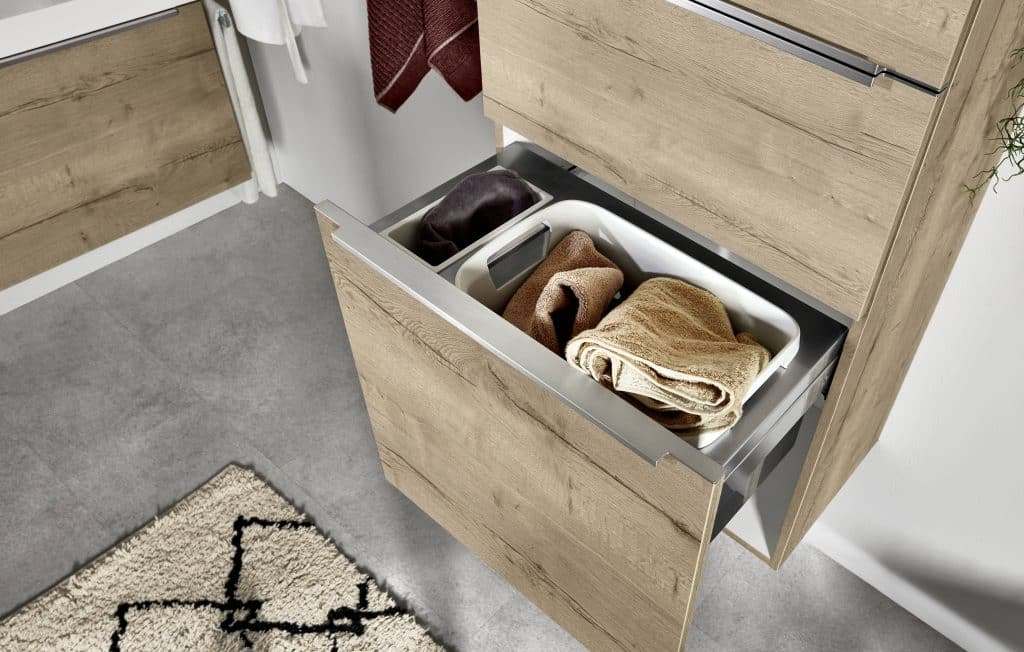 Un tiroir ouvert en bois avec des bacs à vêtements à l'intérieur