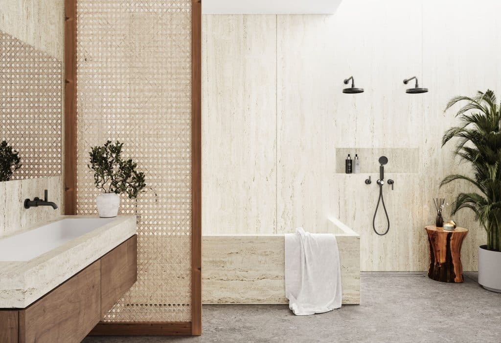 Une salle de bain beige avec une baignoire et une plante