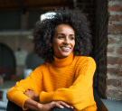 Personal kitchener chez Elton (architecte cuisiniste), femme souriante aux cheveux frisés et pull jaune