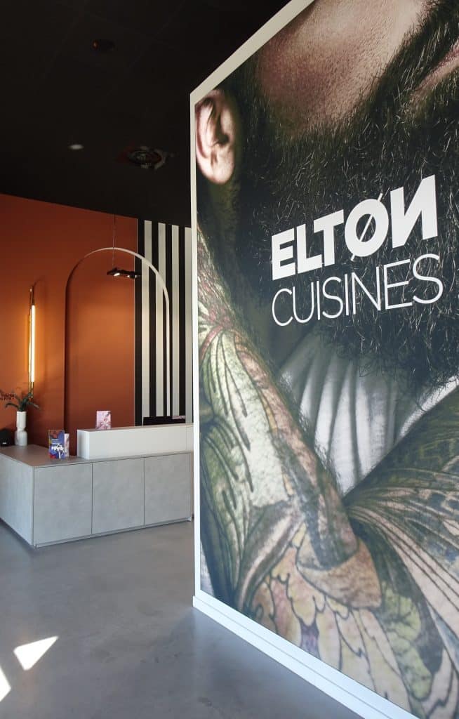 Entrée d'un magasin Elton avec une grande affiche et le logo