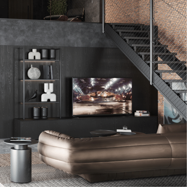 Un canapé couleur cuivre à côté d'un escalier et en face d'une télévision allumée