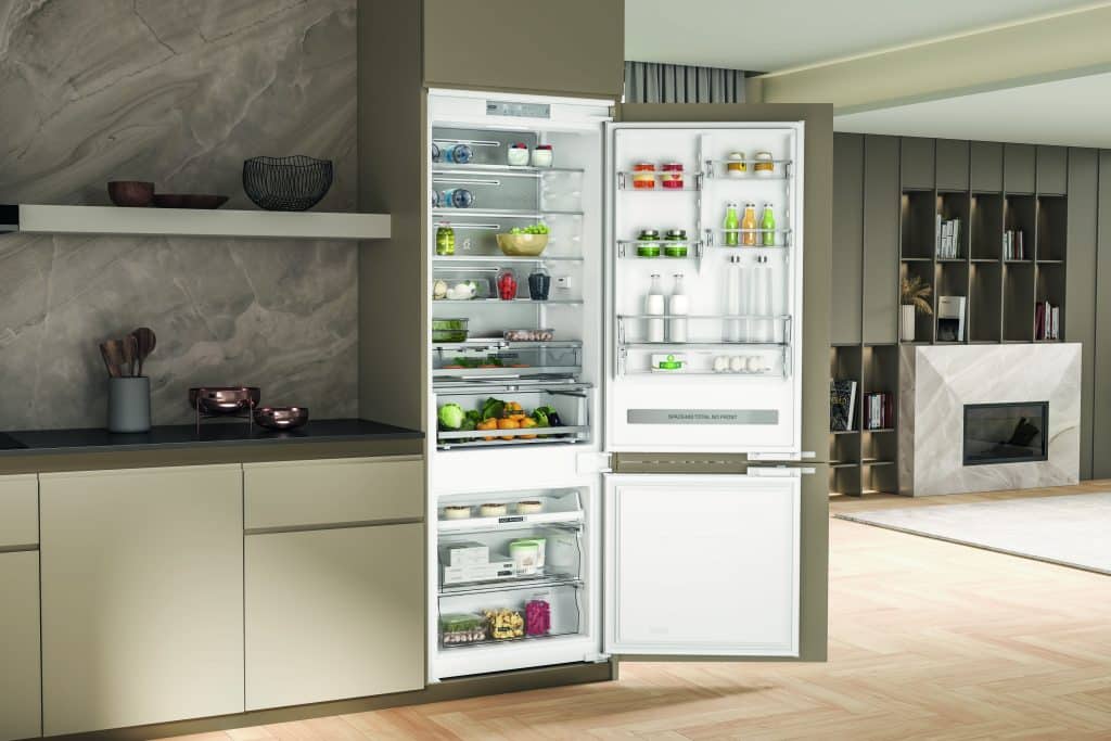 Frigo ouvert avec des aliments à l'intérieur dans une cuisine verte