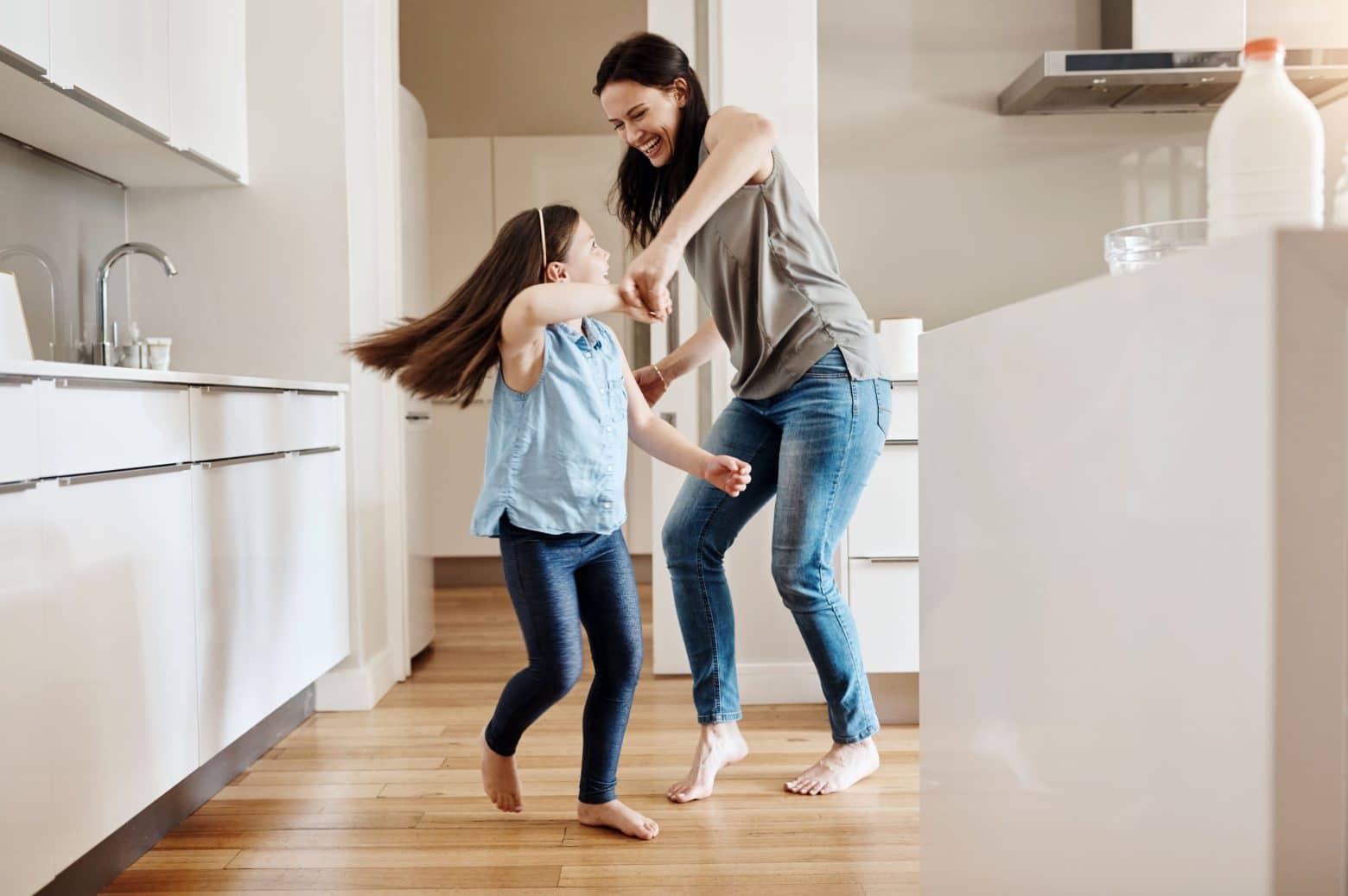 Une mère et sa fille qui dansent dans la cuisine