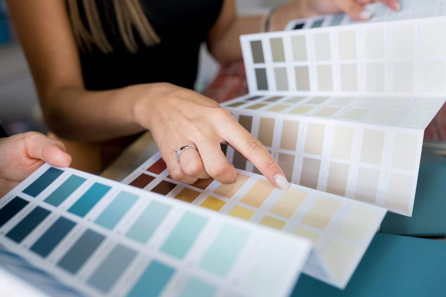 Une femme qui montre du doigt une couleur sur un nuancier de couleurs