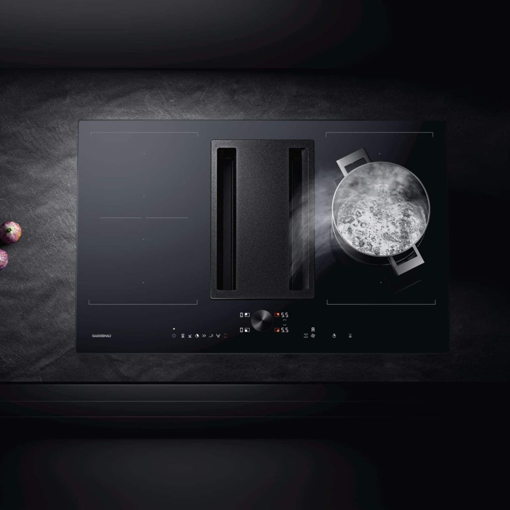 Plaque de cuisson noire avec hotte intégrée qui aspire la fumée d'une casserolle